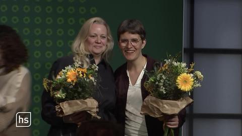 Anna Lührmann und Julia Frank auf Bühne mit Vlumensträußen in den Händen