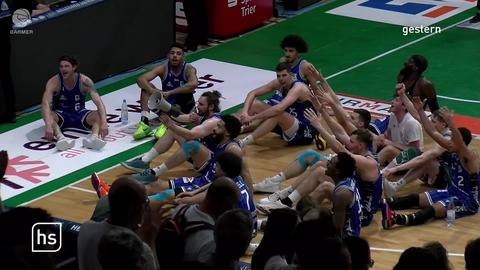 Basketballer sitzen in Halle auf Boden