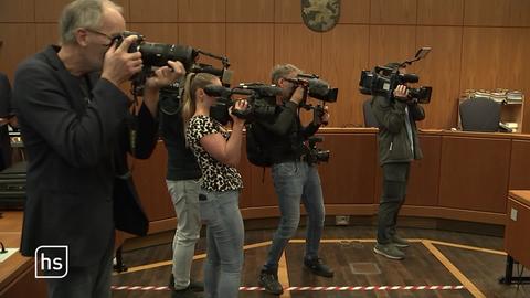 Menschen mit Kameras filmen in Gerichtssaal.