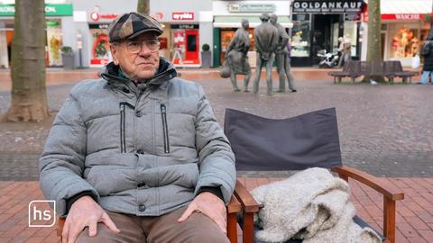 älterer Mann sitzt auf Stuhl und erzählt