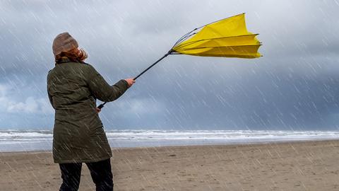 Umgeklappter Regenschirm bei Sturm am Strand