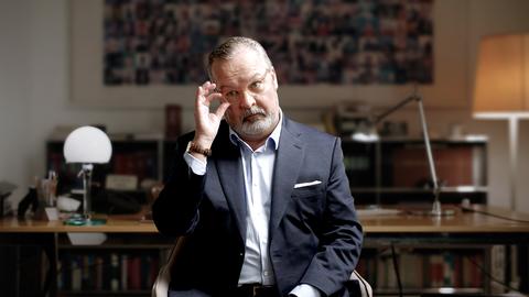 Rechtsanwalt Christian Schertz sitzt im Anzug in seinem Büro. 