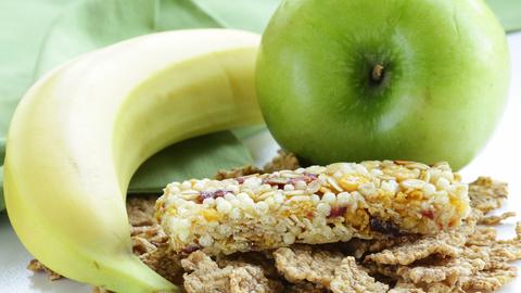 Ein Müsli-Riegel, eine Banane und ein Apfel