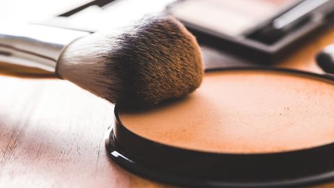 Make-Up Puder und ein Pinsel 