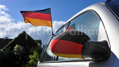 Deutschland-Flaggen über Autospiegel und aus dem Fenster
