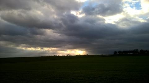 Ein grünes Feld mit bewölktem Hintergrund.