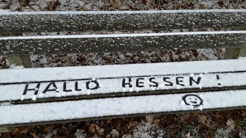 "hallo hessen" in den Schnee auf einer Bank geschrieben.