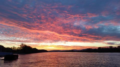 Bewölkter Sonnenuntergang über einem See. 