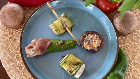 Gefüllte Champignons mit Frischkäse und Schinken, gefüllte Zucchiniröllchen mit Halloumi und Tomate, gefüllte Bratpaprika im Speckmantel