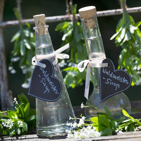 Zwei durchsichtige Glasflaschen Waldmeistersirup