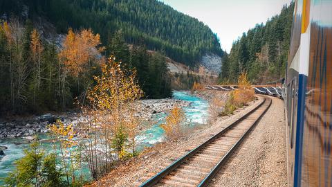 Ein Zug fährt durch eine Berglandschaft in Kanada