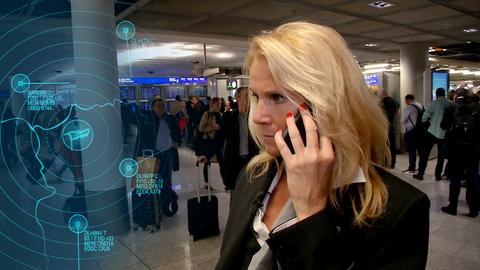 Terminal Duty Managerin Catharina Jud telefoniert. Im Hintergrund stehen viele Menschen in einer Warteschlange.