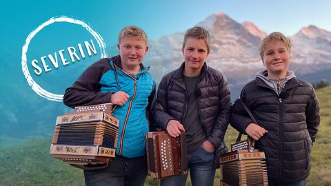 Severin, David und Mika vor den Bergen mit Zieharmonikas.