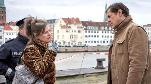 Im Lübecker Industriegebiet am Hafen wird die Leiche des Schauspielers Roland Freesmann gefunden. Finn Kiesewetter (Sven Martinek, r.) befragt eine Zeugin vor Ort, Heidi Lange (Christiane Filla, l.), die den Toten gefunden hat.