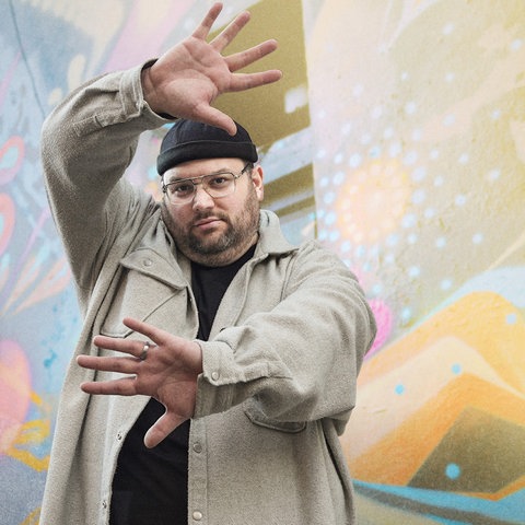 Chris Fandrey, Profitänzer und Choreograf vor einem Graffiti. 