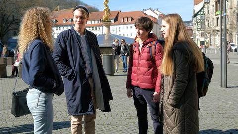 Lotte (Anne Sophie Triesch, r.) ist nicht begeistert, dass Luisa (Pauline Angert, l.) in Eisenach bleiben will: ihr Freund Lenny (Richard Kreutz, 2.v.l.) flirtet ungeniert mit ihrer älteren Schwester. Paul Kleist (Julian König, 2.v.r.) wird Zeuge der Eifersuchtsszene.