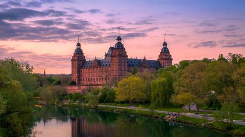 Das Schloss Johannisburg in Aschaffenburg hinter dem Main im Abendlicht.