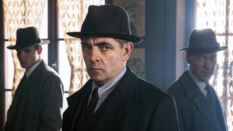 Kommissar Maigret (Rowan Atkinson) und seine Inspektoren Lapointe (Leo Staar, li.) und Janvier (Shain Dingwall, re.) nehmen das verlassene Bistro des Ermordeten unter die Lupe.